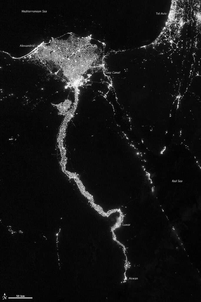 NASA image acquired October 13, 2012 The Nile River Valley and Delta comprise less than 5 percent of Egypt’s land area, but provide a home to roughly 97 percent of the country’s population. Nothing makes the location of human population clearer than the lights illuminating the valley and delta at night. On October 13, 2012, the Visible Infrared Imaging Radiometer Suite (VIIRS) on the Suomi NPP satellite captured this nighttime view of the Nile River Valley and Delta. This image is from the VIIRS “day-night band,” which detects light in a range of wavelengths from green to near-infrared and uses filtering techniques to observe signals such as gas flares, auroras, wildfires, city lights, and reflected moonlight. The city lights resemble a giant calla lily, just one with a kink in its stem near the city of Luxor. Some of the brightest lights occur around Cairo, but lights are abundant along the length of the river. Bright city lights also occur along the Suez Canal and around Tel Aviv. Away from the lights, however, land and water appear uniformly black. This image was acquired near the time of the new Moon, and little moonlight was available to brighten land and water surfaces. NASA Earth Observatory image by Jesse Allen and Robert Simmon, using VIIRS Day-Night Band data from the Suomi National Polar-orbiting Partnership. Suomi NPP is the result of a partnership between NASA, the National Oceanic and Atmospheric Administration, and the Department of Defense. Caption by Michon Scott. Instrument: Suomi NPP - VIIRS  Credit:  NASA Earth Observatory.